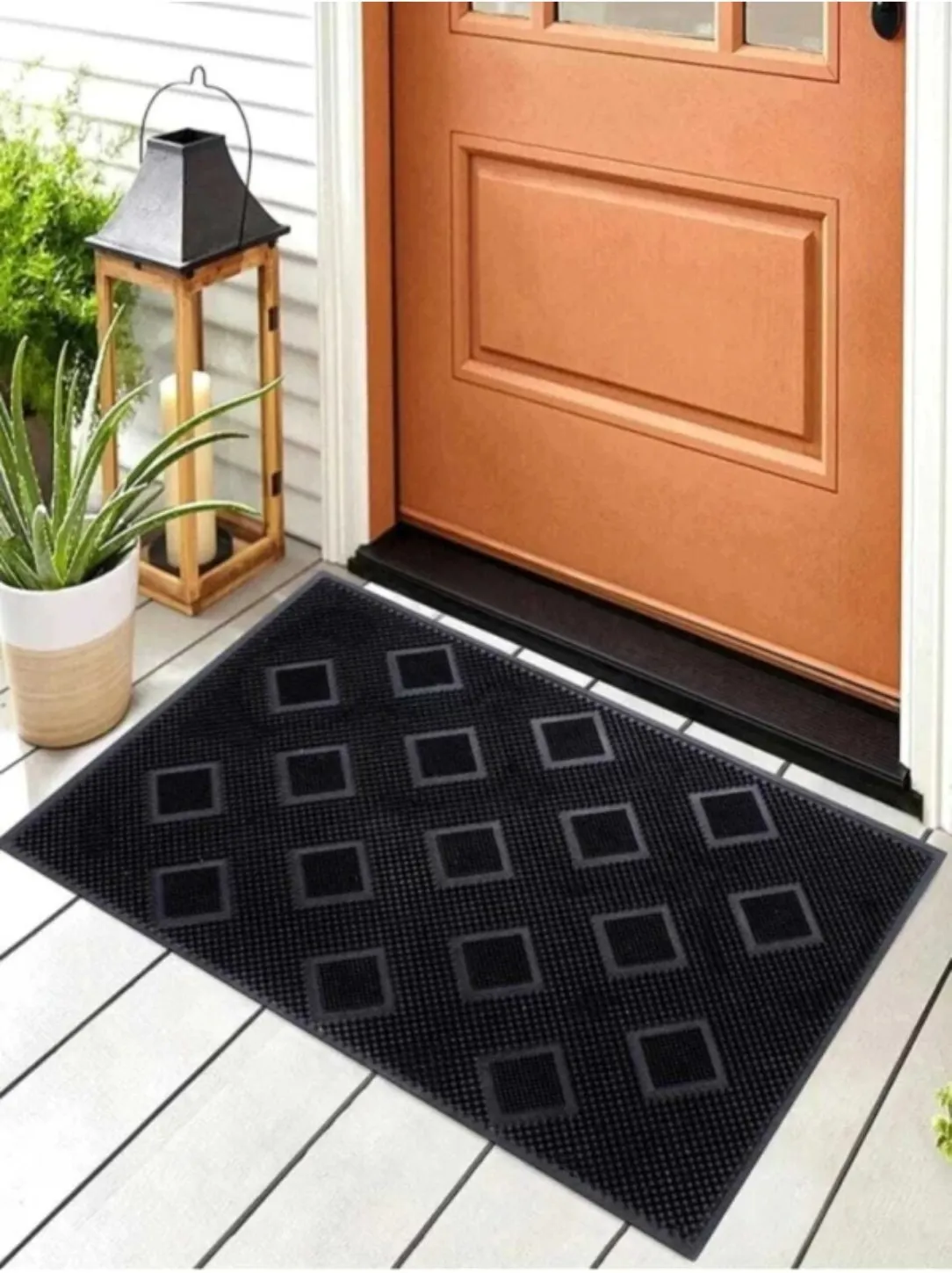 Black rubber pin mat with a raised diamond pattern at a front door